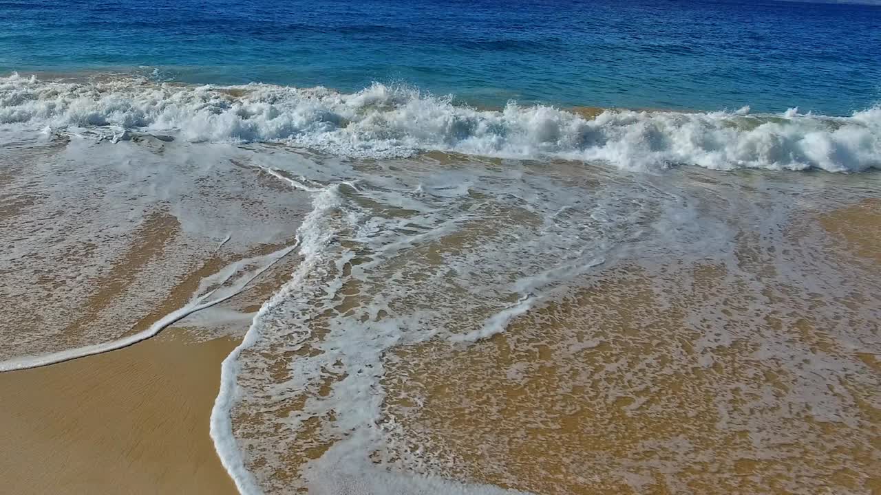 panorámica de las olas rompiendo en la playa de arena en maui hawaii con un hermoso cielo y agua