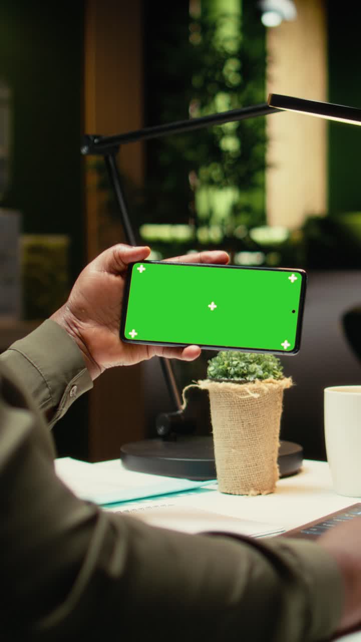 Vertical Video Chroma key on phone held by african american woman checking data reports