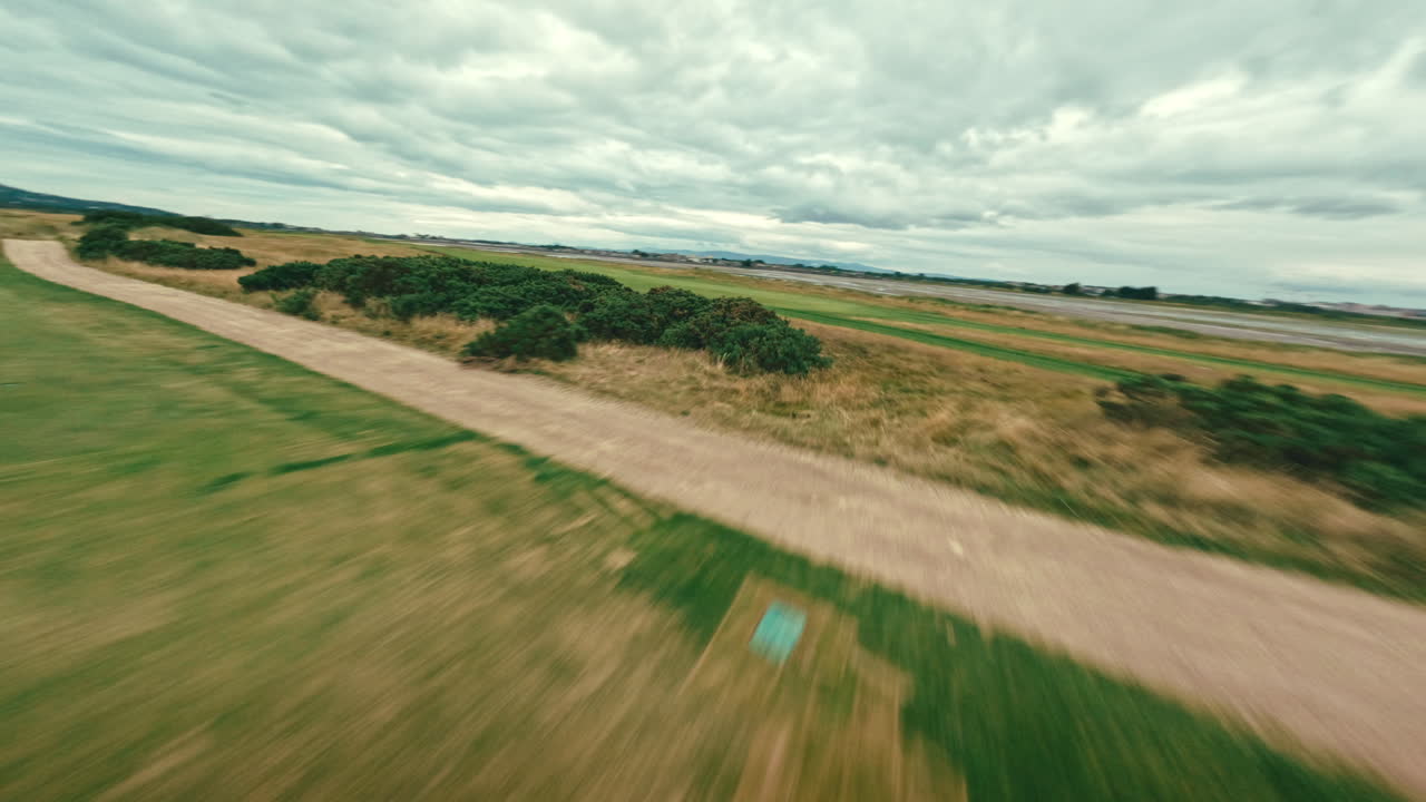 fpv drone flyover campo de golf, cerca de la casa del club y a lo largo de la hierba verde de par 5 en el campo de golf de ireland links