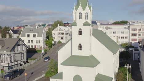 s'élevant à côté d'une église idyllique révélant des maisons traditionnelles islandaises dans la capitale, aérienne