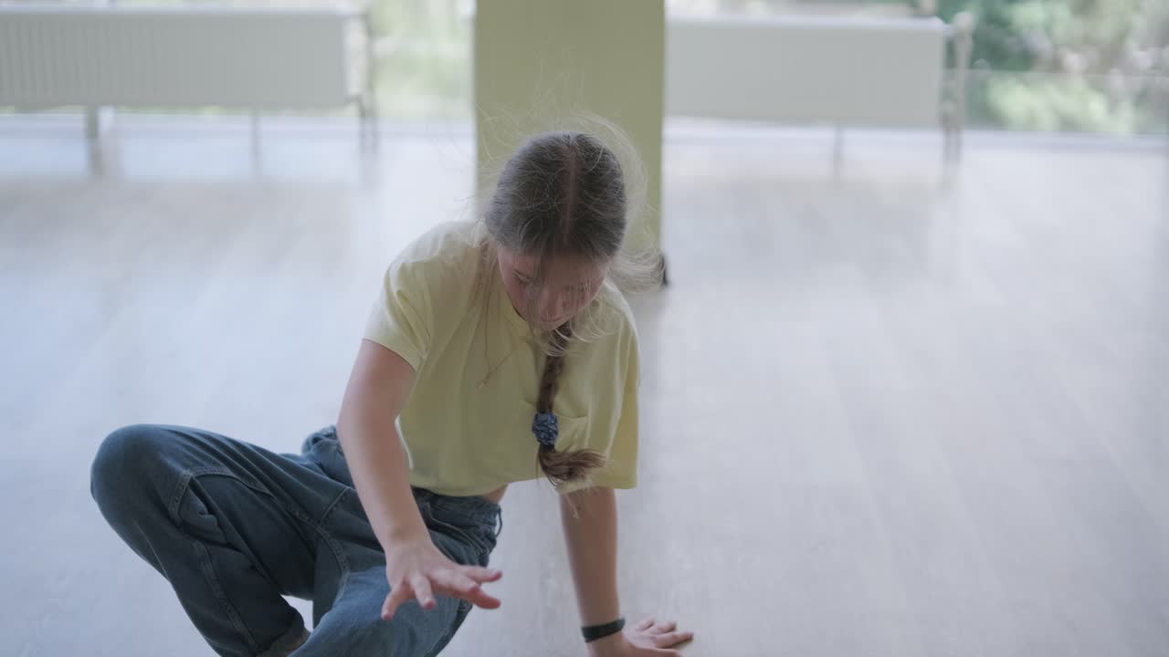 스타일리시한 젊은 소녀가 브레이크 댄스와 안무로 춤을 춘다.