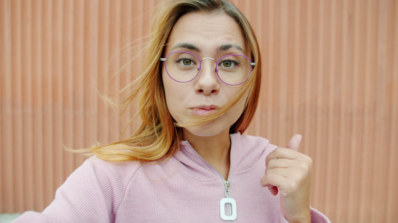 Woman wearing glasses and a pink hoodie