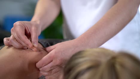 crop therapist inserting needle into shoulder of patient