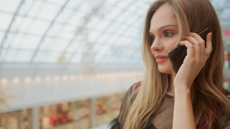 beautiful-girl-talking-on-smartphone-and-sitting-with-shopping-bags-in-mall