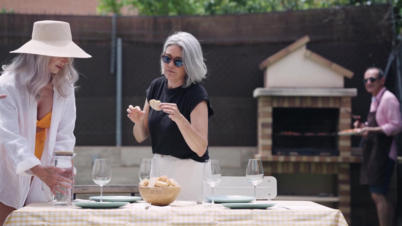Mature Women Preparing Outdoor Table for Barbecue Lunch