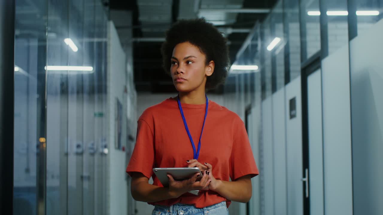 Woman using tablet in office hallway