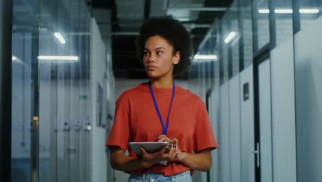 woman using tablet in office hallway