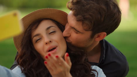 dulce chica y chico haciendo una selfie en el parque. pareja mostrando gestos con las manos en un picnic