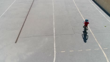 aerial view of young bicyclist riding bike at empty stadium