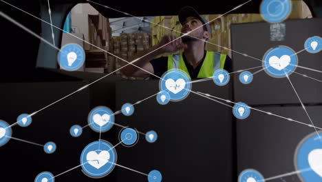 animación de una red de iconos digitales sobre un trabajador caucásico apilando cajas en una furgoneta de entrega.