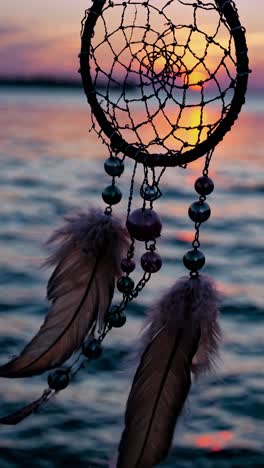 dreamcatcher at sunset over water, captured from a low angle. the video evokes tranquility with warm
