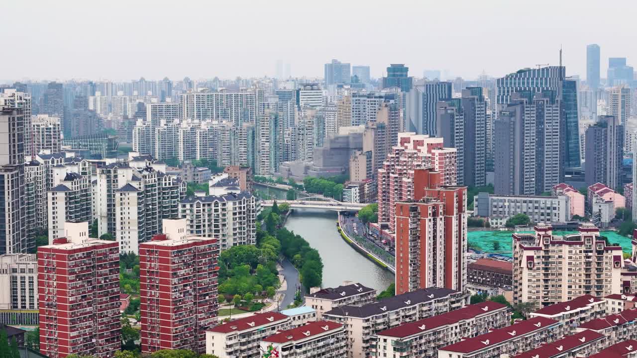 Drone view of Shanghai cityscape on a hazy day. Features buildings along Suzhou Creek, showcasing urban density and river view. China. UHD.