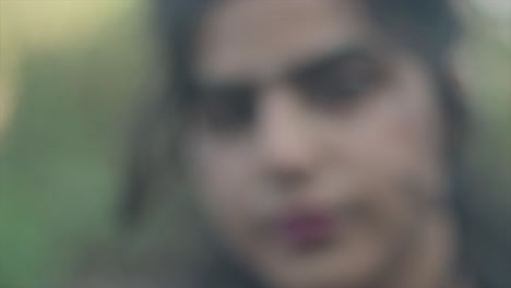 카메라를 바라보는 코걸이, 흰색 연극 화장, 빨간 립스틱을 한 인도 젊고 예쁜 여성의 슬로우 모션 클로즈업 샷, 여성이 흐려지는 동안