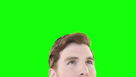 caucasian man looking up on green background