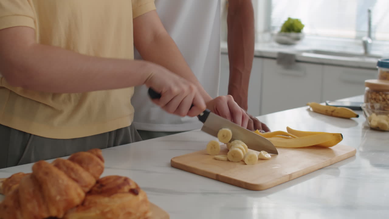 Woman Cutting Banana and Kissing Boyfriend when Cooking Together
