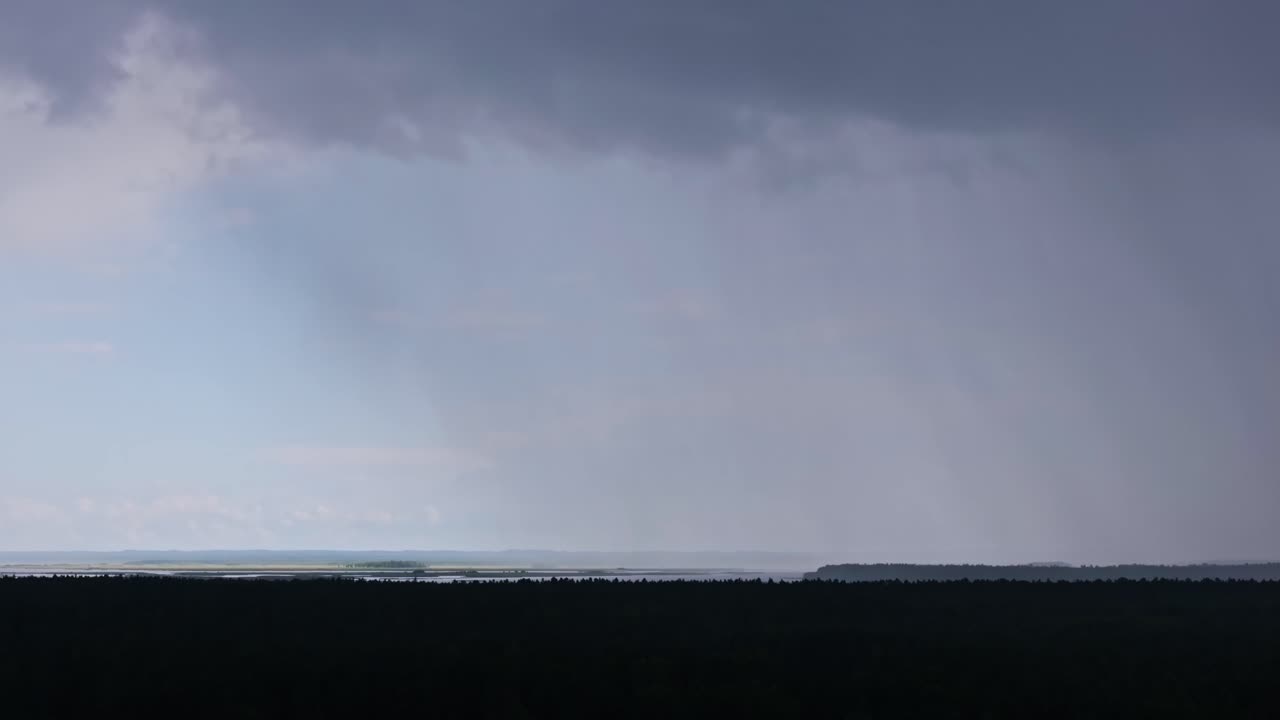 Heavy rain and storm clouds over forest landscape, climate change uncertainty