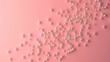 scattered white pearls on a soft pink background