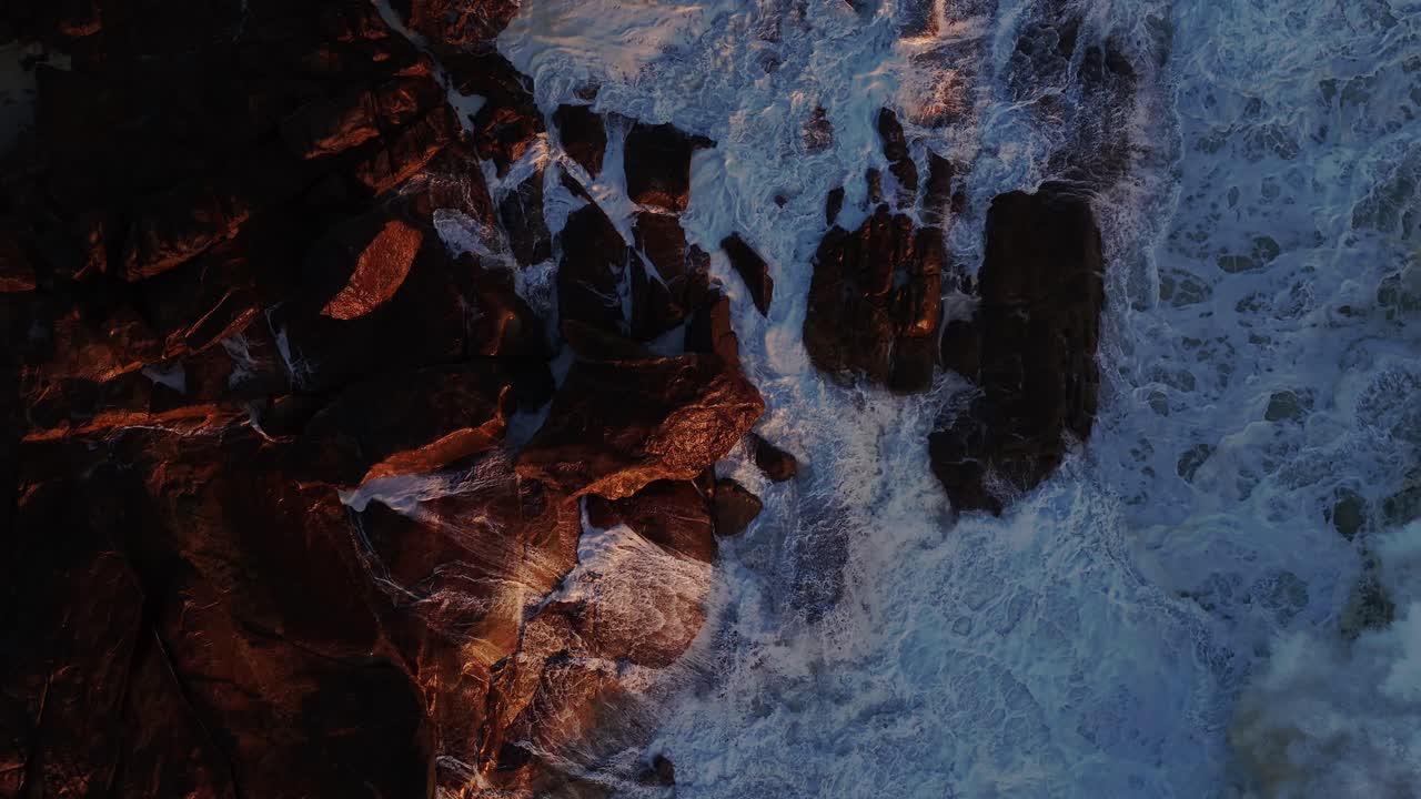 Aerial view of the waves hitting the rocks off the coast of Portugal in slow motion