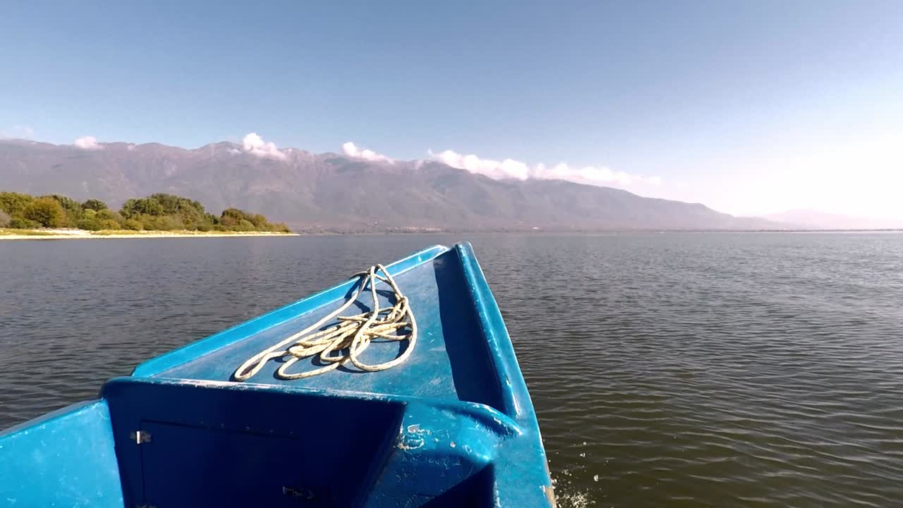 un barco moviéndose hacia una montaña en un lago