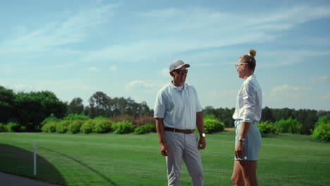 Two-golfers-talking-sport-on-course-field.-Golf-players-chat-on-fairway-grass.