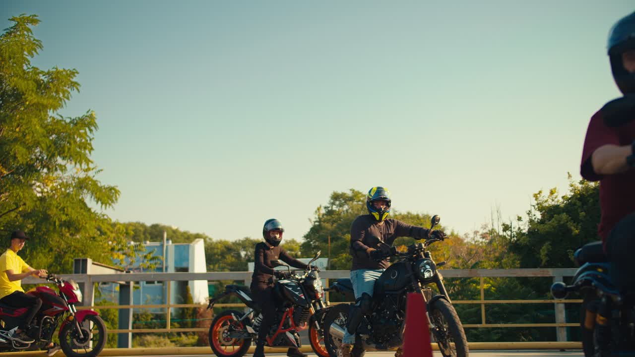 운동장에서 자전거를 타는 동안 보호복과 장애물 헬 ⁇ 을 입은 모터사이클리스트의 회사