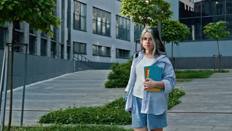 estudiante adolescente caminando por el campus con libros