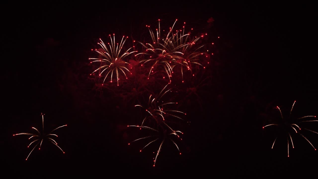 Real fireworks on deep black background sky, beautiful colorful fireworks shiny display at night, real time 4k footage.
