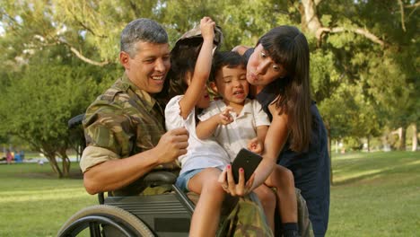 funny mom taking selfie with two kids and disabled dad