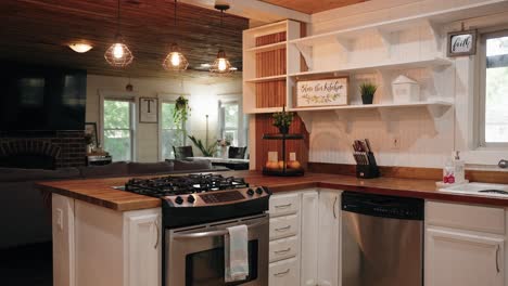 a panning shot of the stove and surrounding cabinets in a modern farmhouse with white finishes