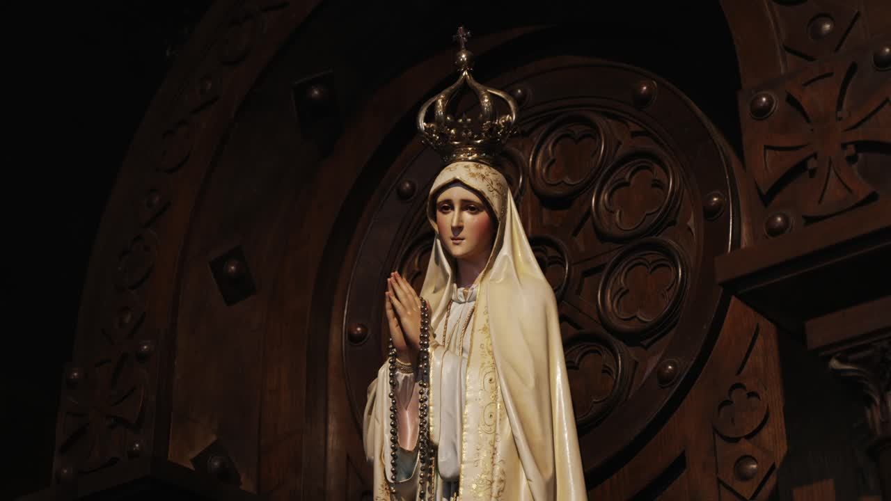 Elegant statue of Our Lady of Fatima with a crown and rosary, framed in wood