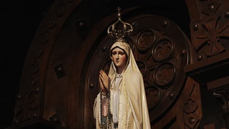 elegant statue of our lady of fatima with a crown and rosary, framed in wood