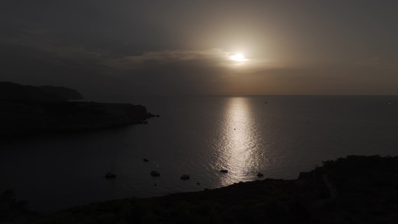 Drone kuvaa hetkeä ennen auringonpimennystä Ibizan rauhallisen rannikon yllä lähellä Portinatxia. Vangitsevia kohtauksia, eloisia värejä, elokuvallista laatua ja runsaita yksityiskohtia.