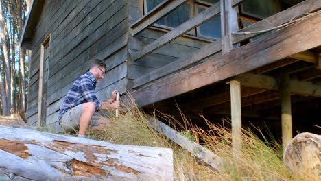 Male-hiker-hammering-in-nail-4k