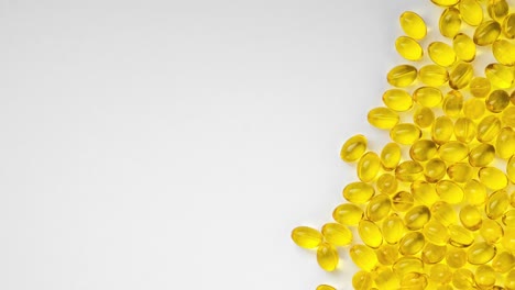 yellow transparent pills on a white background with a copy space left, stop motion video. pills with vitamin d3