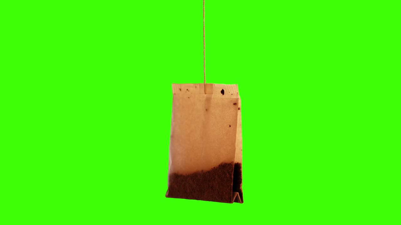 Single used teabag with brew on green screen