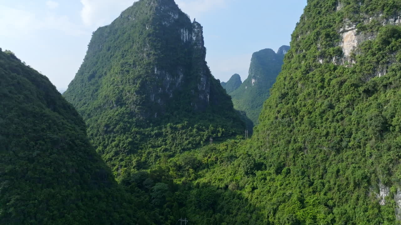 Aerial view rising in middle of karst mountains, sunny day in Yangshuo, China