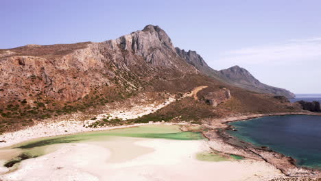 aerial truck shot of balos beach and surrounding mountains in northern crete on beautiful sunny day