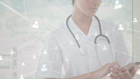 animación de una red de conexiones con iconos sobre una doctora caucásica que usa una tableta