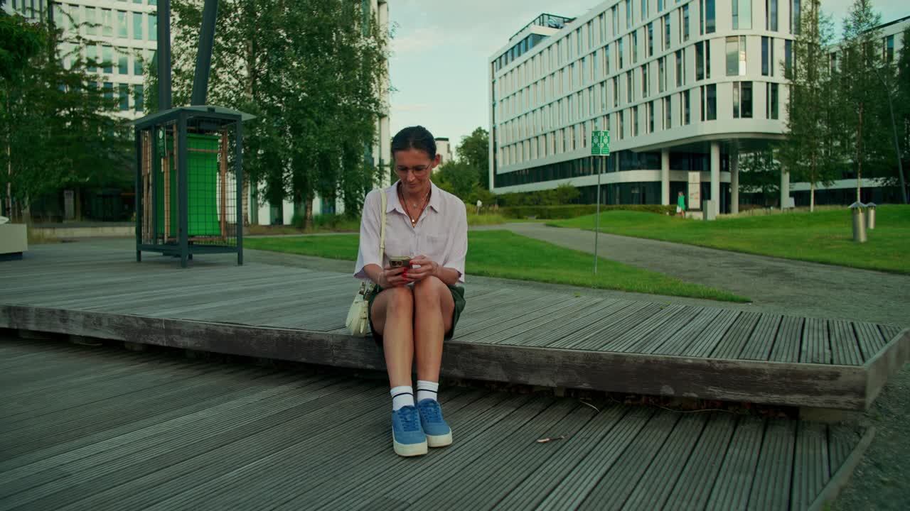 Una mujer usando su teléfono en un parque
