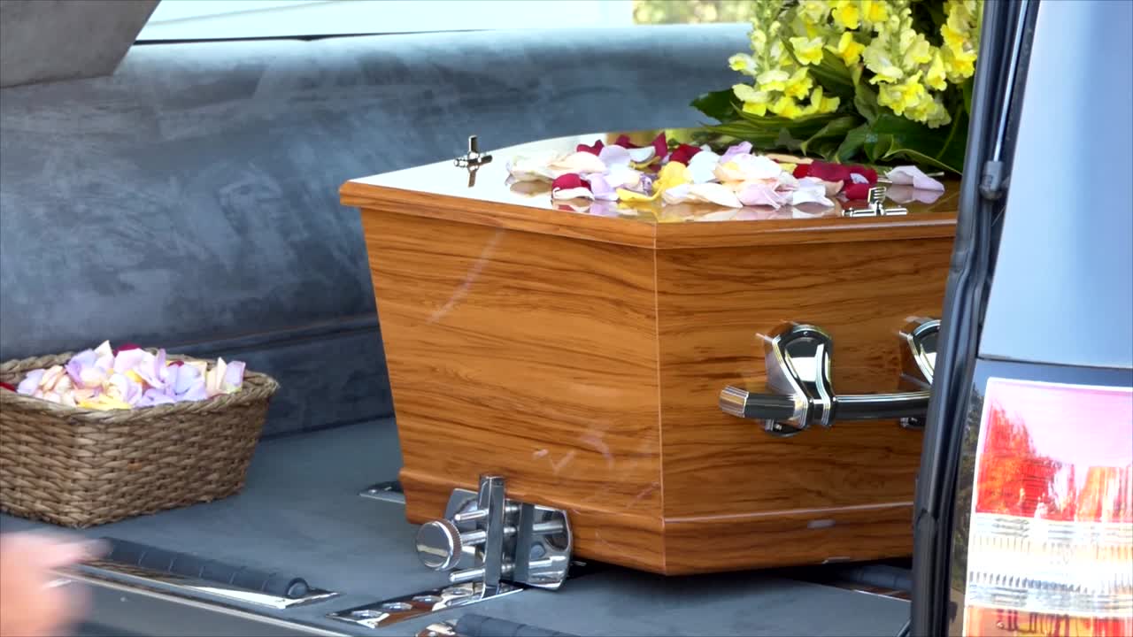 captura de pantalla de un ataúd funerario en un coche fúnebre o capilla o entierro en el cementerio