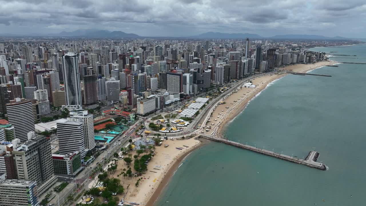 Estalbishing aerial view of Fortaleza, Brazil, big city beachfront buildings and dock, Atlantic ocean cityscape