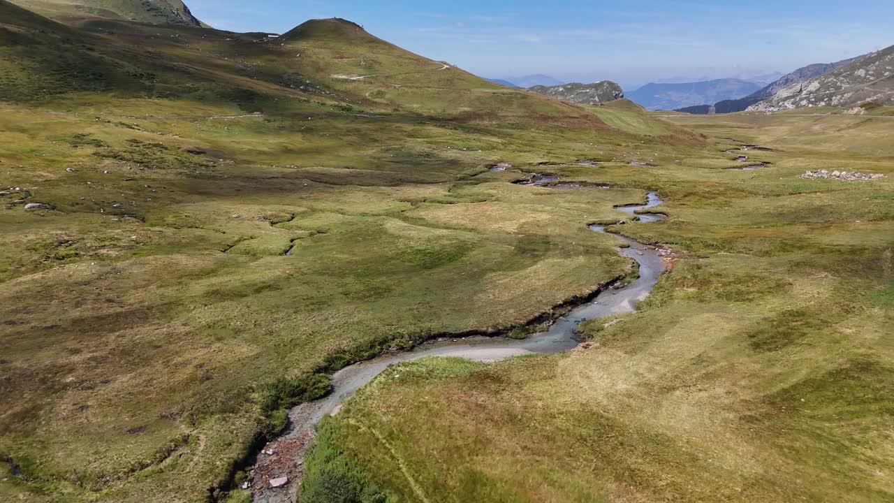 Drone che sorvola una valle montana con un fiume nel mezzo in 4K