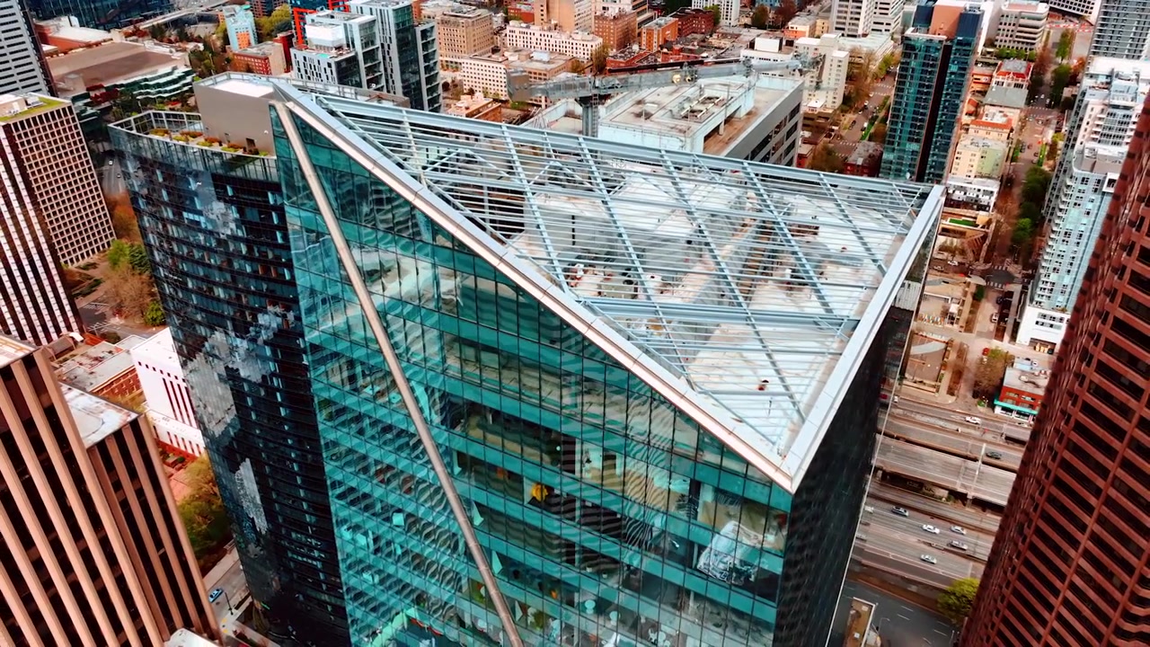 Rascacielos futurista de cristal y hormigón. Dron alejándose de la cima del edificio de día. Seattle, Washington, EE. UU.