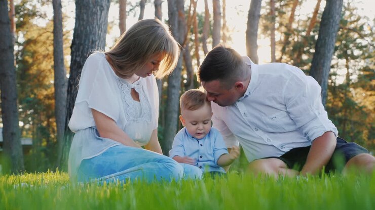 Famiglia con un bambino si riposa nella natura, conversando e trascorrendo del buon tempo insieme.