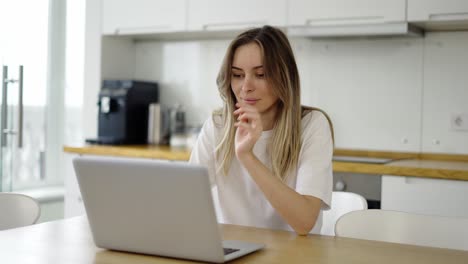 smiling woman reading good news or surfing internet on laptop