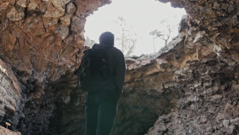 randonneur admirant les grottes de tube de lave du monument national d'el malpais au nouveau mexique