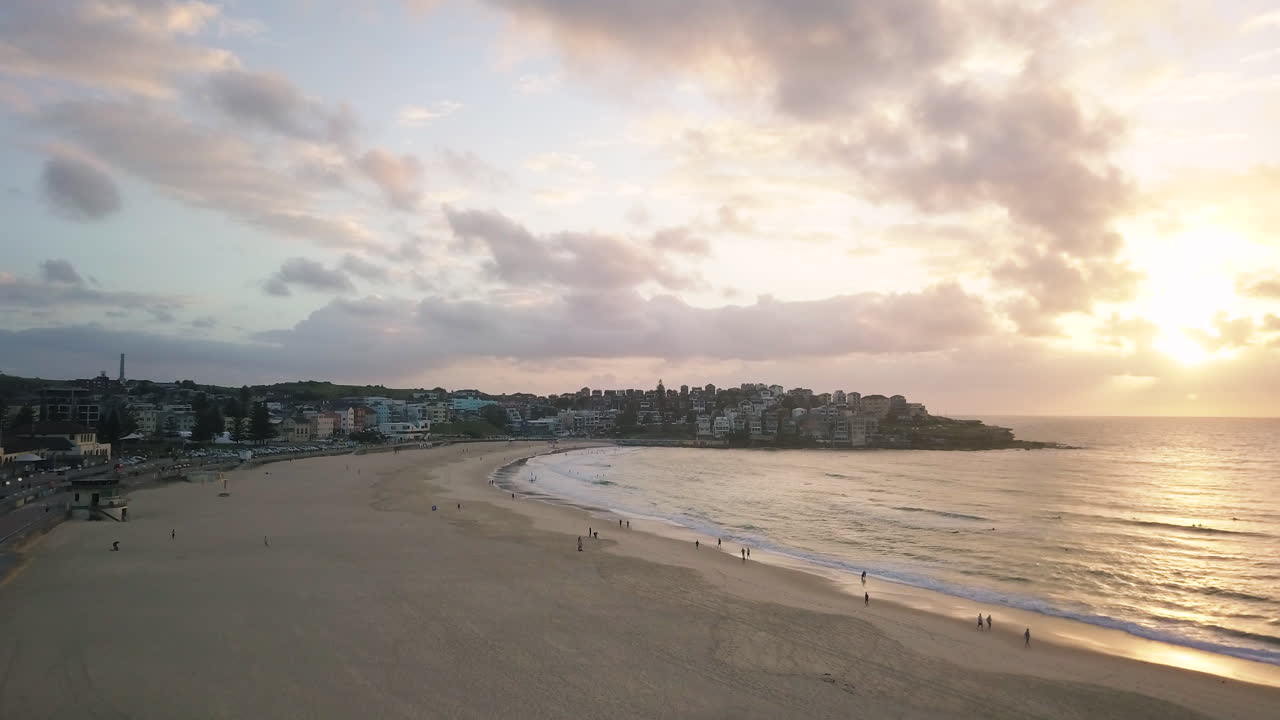 gente paseando por la playa de bondi en sydney, nueva gales del sur, en un hermoso amanecer - drone aéreo