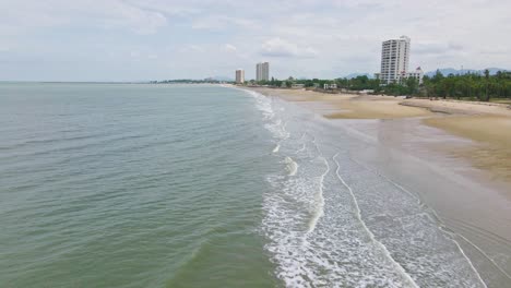 playa de cha-am con olas del océano a lo largo de la costa arenosa en tailandia