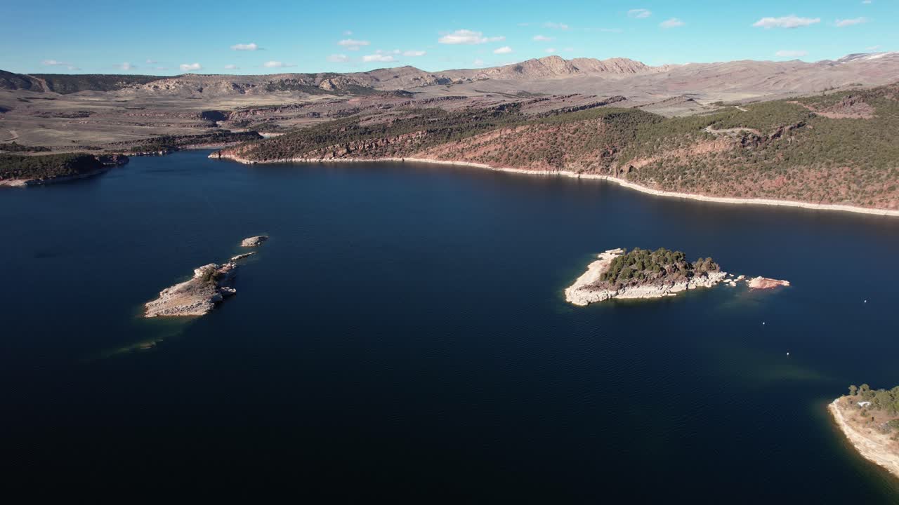 불타는 협곡 저수지 유타 와이오밍 국경 미국, 화창한 날 레크리에이션 지역, 드론 샷에 있는 바위 섬의 공중 전망