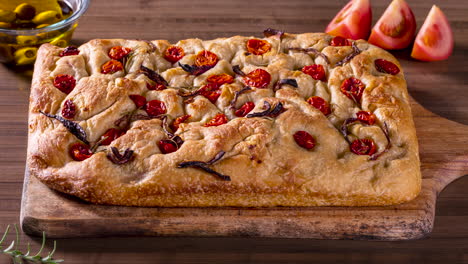 traditional italian focaccia with pepperoni, cherry tomatoes, black olives, rosemary ando onion - homemade flat bread focaccia